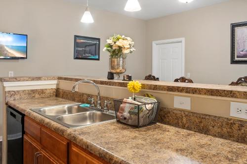 a kitchen counter with a sink and a vase of flowers at Mid-City Serenity in Huntsville