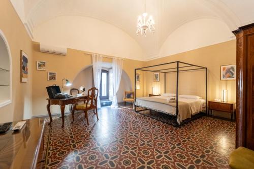 a bedroom with a bed and a desk in a room at La Dimora degli Attori in Catania