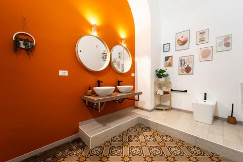 an orange bathroom with a sink and a mirror at La Dimora degli Attori in Catania