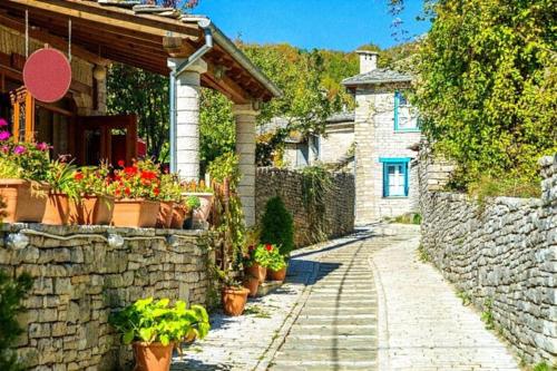 a stone pathway leading to a house with potted plants at Σπίτι στο νησί Ιωαννίνων LAGO MINI SUITE in Ioannina