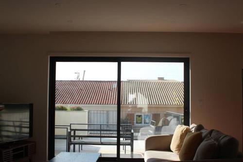 a living room with a couch and a large window at Casa Francisca praia de Mindelo in Mindelo