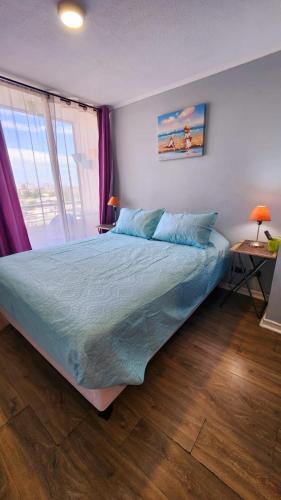a bedroom with a large bed and a window at Departamentos Amoblados Chileruca in Santiago
