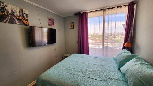 a bedroom with a bed and a large window at Departamentos Amoblados Chileruca in Santiago