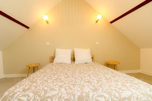 Un dormitorio con una cama grande con dos mesas. en Maison avec spa proche Giverny, en Vétheuil