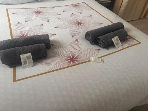 a bed with three rolled up towels on it at La petite récréation, Place de parking inclus in Dieppe