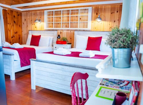 deux lits dans une chambre aux murs en bois dans l'établissement Cottage 3 - Pet Friendly - 1 Bedroom / 1 Bath, à Wolfeboro