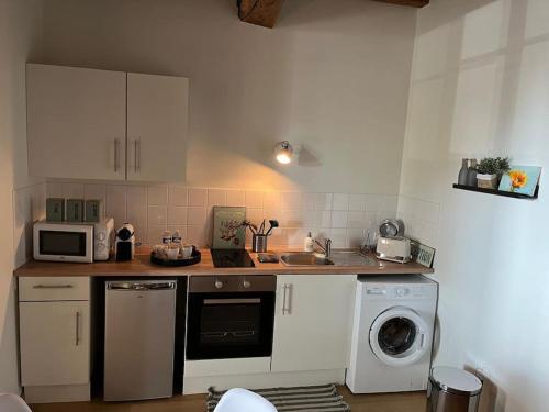 a kitchen with a washer and a sink and a dishwasher at La Maison aux volets bleus 37 m3, Bords de Saône in Chalon-sur-Saône
