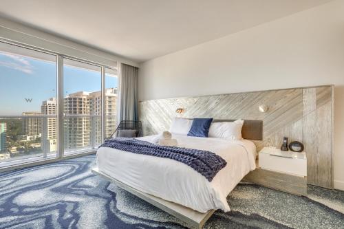 a bedroom with a large bed and a large window at Steps to Fort Lauderdale Beach Oceanfront Condo in Fort Lauderdale