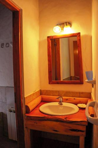 a bathroom with a sink and a mirror at Lelikelen Cabañas del Bosque in Villa La Angostura