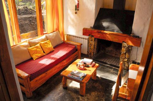 a living room with a couch and a fireplace at Lelikelen Cabañas del Bosque in Villa La Angostura