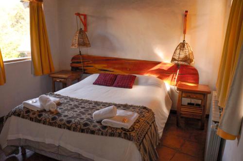 a bedroom with a bed with towels on it at Lelikelen Cabañas del Bosque in Villa La Angostura
