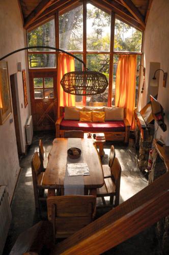 a dining room with a table and chairs and a window at Lelikelen Cabañas del Bosque in Villa La Angostura
