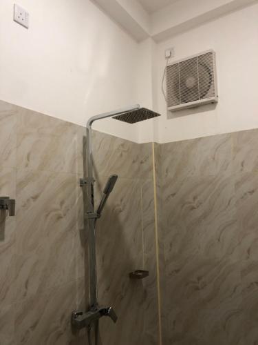 a shower with a glass door and a fan at Traumvilla Mirissa in Mirissa