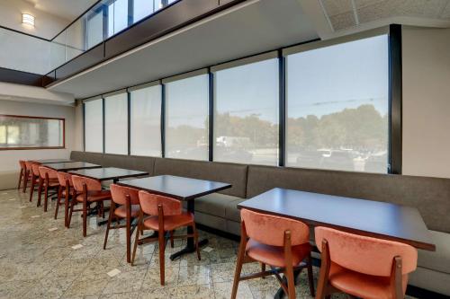 a row of tables and chairs in a room with windows at Drury Inn & Suites Charlotte University Place in Charlotte