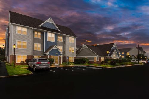 a large house with a car parked in a parking lot at Sonesta ES Suites Charleston in Charleston