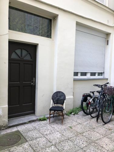 une porte noire et une chaise devant une maison dans l'établissement Studyo cosy 400 metre sacre ceour, à Paris