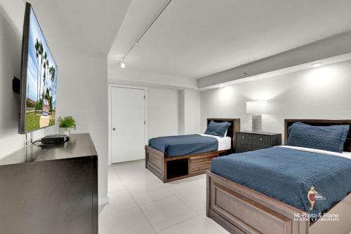 a bedroom with two beds and a television in it at Bahia Mar-Solare Tower, Beachfront Resort with Two Pools in South Padre Island