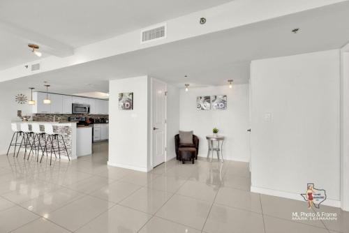 a living room with white walls and a table and chairs at Bahia Mar-Solare Tower, Beachfront Resort with Two Pools in South Padre Island
