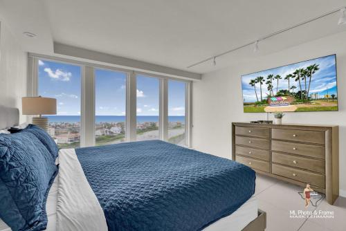 a bedroom with a blue bed and a large window at Bahia Mar-Solare Tower, Beachfront Resort with Two Pools in South Padre Island