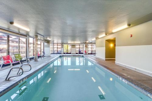 a large swimming pool with red chairs in a building at Walk to the Lake Chelan Condo with Mtn Views! in Chelan