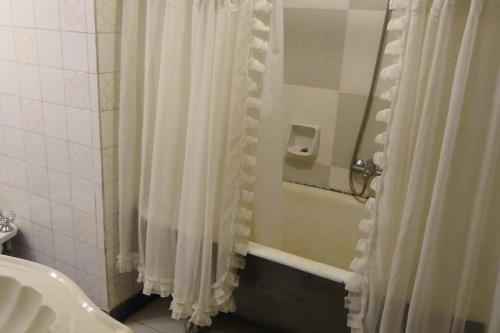 Un baño con cortina de ducha y lavabo. en casa de campo temporario, en Yala