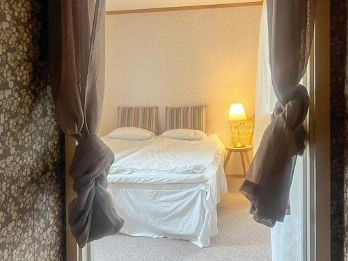 a bedroom with a white bed and a window at 6 person holiday home in LÖNASHULT in Lönashult