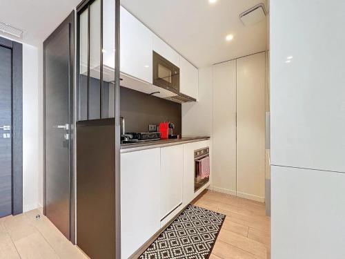  La cuisine est équipée de placards blancs et d'un réfrigérateur. dans l'établissement 3P BETWEEN CROISETTE BEACHES AND ANTIBES STREET, à Cannes