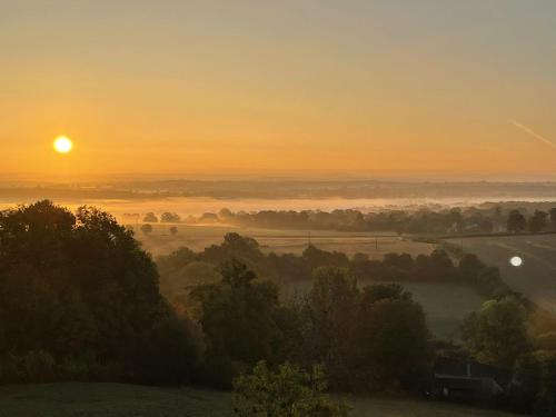 a misty sunrise with the sun rising over a field and a road at Villa Champallement in Champallement