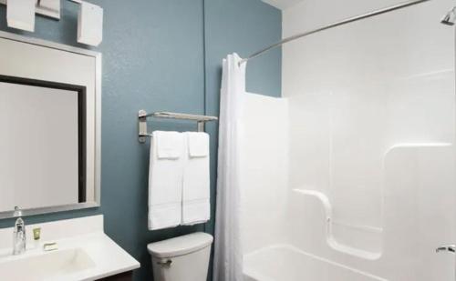 a bathroom with a toilet and a sink and a shower at WoodSpring Suites Huntsville - Research Park in Huntsville