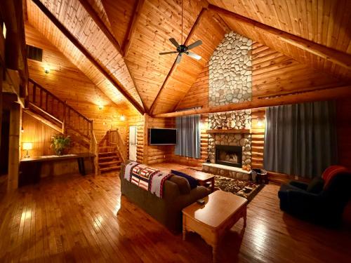 a living room with a couch and a fireplace at Serene Log Cabin Forest Retreat in LaPorte