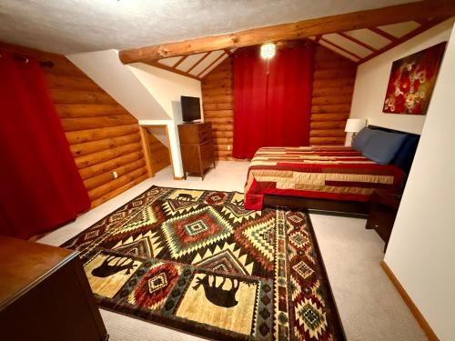 a bedroom with two beds and a rug on the floor at Serene Log Cabin Forest Retreat in LaPorte
