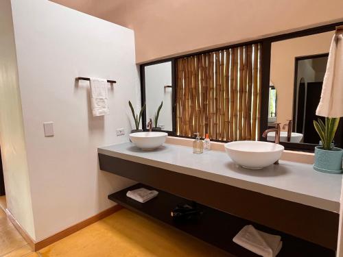 a bathroom with two sinks and a large mirror at Pachakuti Eco-vida Hotel in Caicedonia