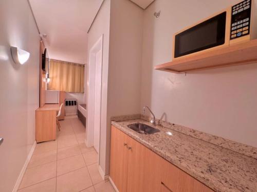 a small kitchen with a sink and a bathroom at Igaras Hotel in Otacílio Costa