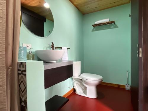 a bathroom with a white toilet and a sink at Pachakuti Eco-vida Hotel in Caicedonia