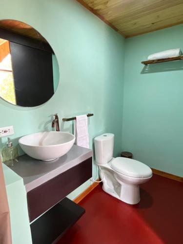 a bathroom with a white toilet and a sink at Pachakuti Eco-vida Hotel in Caicedonia