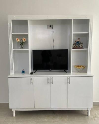 a white entertainment center with a flat screen tv at Hermoso apartamento #13 piso 3 in Machala