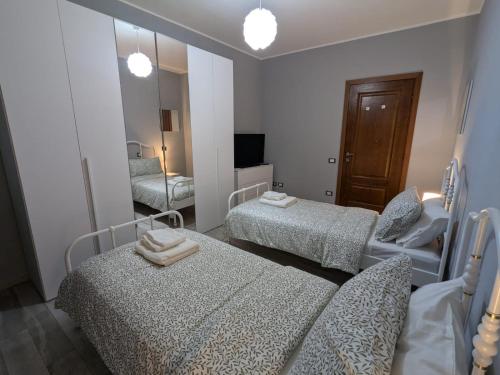 a bedroom with two beds and a mirror at La casa di Jo in Navacchio