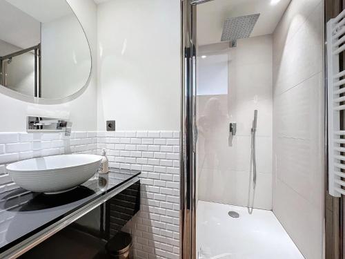 une salle de bain blanche avec un lavabo et une douche dans l'établissement 3P BETWEEN CROISETTE BEACHES AND ANTIBES STREET, à Cannes