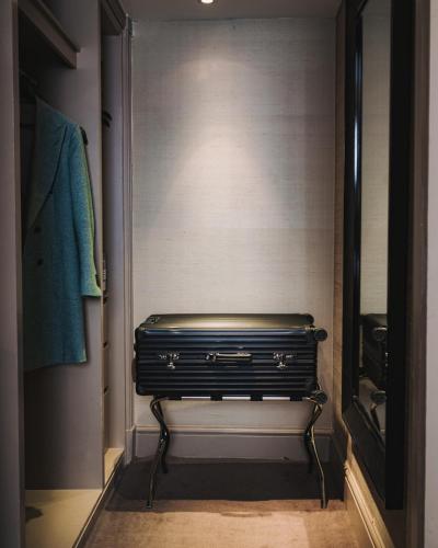 a bench in a walk in closet with a mirror at Althoff St James's Hotel & Club London in London