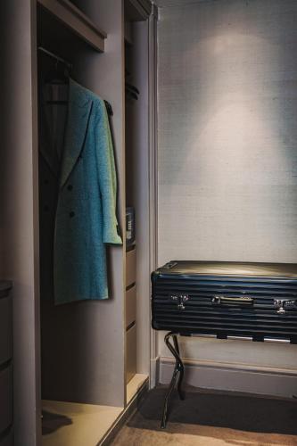 a closet with a green coat hanging on a door at Althoff St James's Hotel & Club London in London
