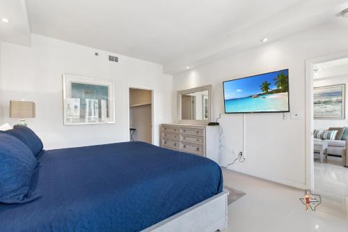 a bedroom with a blue bed and a tv on the wall at Bahia Mar-Solare Tower, Beachfront Resort with Two Pools in South Padre Island