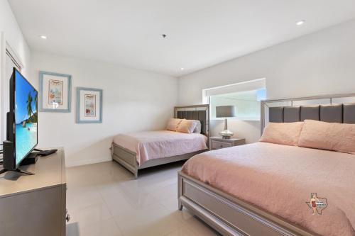 a bedroom with two beds and a flat screen tv at Bahia Mar-Solare Tower, Beachfront Resort with Two Pools in South Padre Island