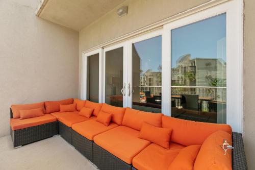 an orange couch in a room with a large window at Bahia Mar-Solare Tower, Beachfront Resort with Two Pools in South Padre Island