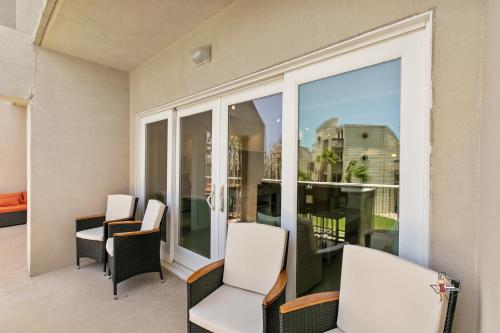 a balcony with white chairs and a large window at Bahia Mar-Solare Tower, Beachfront Resort with Two Pools in South Padre Island