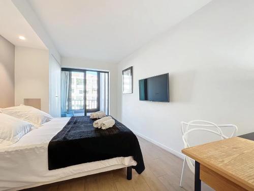 une chambre avec un lit, une table et une télévision dans l'établissement 3P BETWEEN CROISETTE BEACHES AND ANTIBES STREET, à Cannes