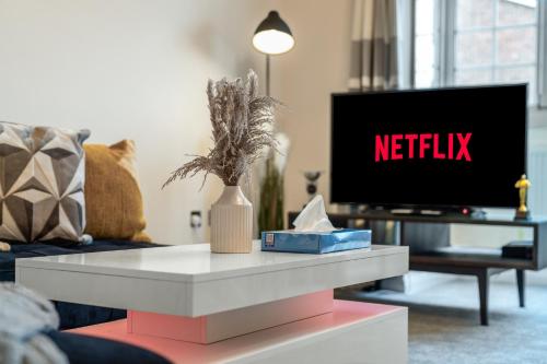 a living room with a tv and a white coffee table at Wilkinsons Home-Free parking, Perfect For Contractors & Weekend getaways, Near London City Airport & Excel in London