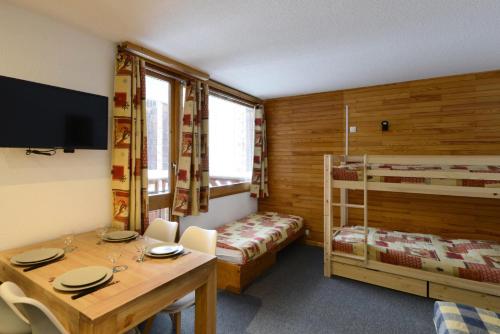 ein kleines Zimmer mit einem Tisch und einem Etagenbett in der Unterkunft Résidence Carroley B - Chaleureux studio · Proche des pistes · Vue pistes MAE-3785 in Mâcot La Plagne