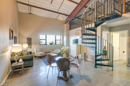 a living room with a table and a spiral staircase at Del Norte Apartment with Loft Walk to Downtown! in Del Norte