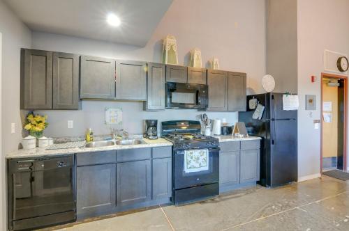 a kitchen with blue cabinets and a black refrigerator at Del Norte Apartment with Loft Walk to Downtown! in Del Norte