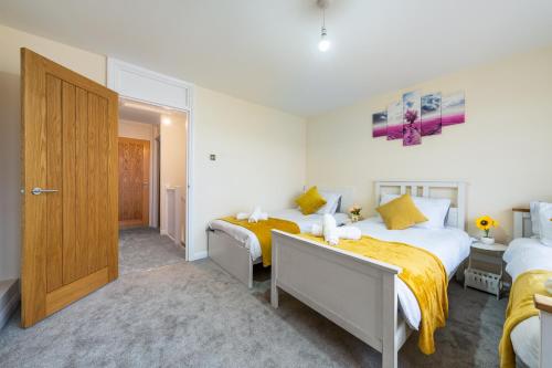a bedroom with two beds and a door at Wilkinsons Home-Free parking, Perfect For Contractors & Weekend getaways, Near London City Airport & Excel in London